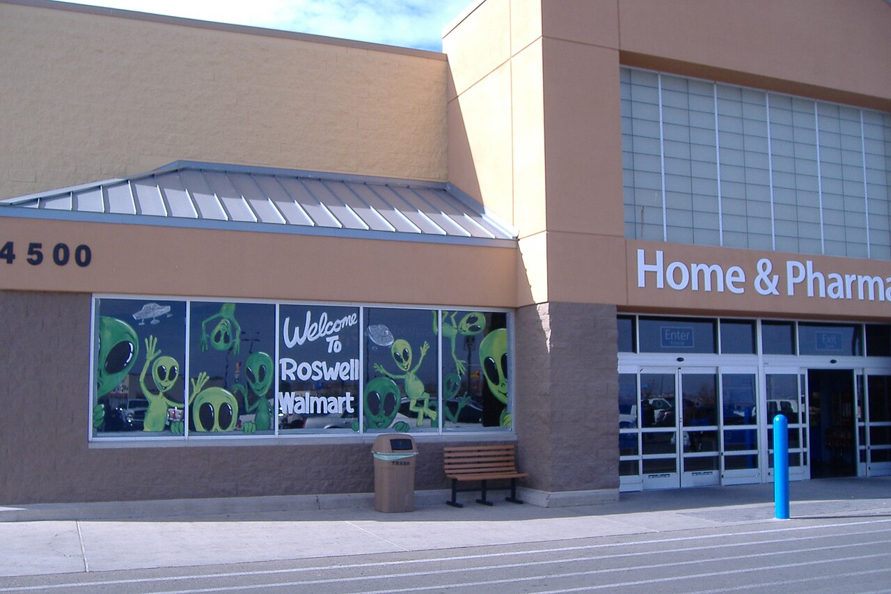 Green aliens painted across the Walmart entrance windows above the words Welcome To Roswell Walmart